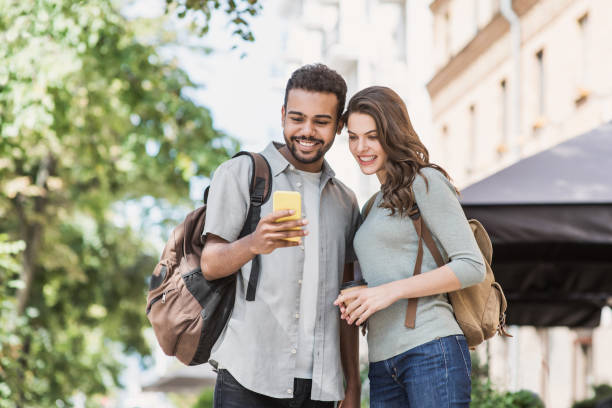 istock Beautiful happy couple using smartphone in a city 1205234404