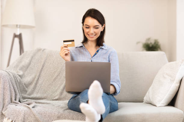 istock Young woman making purchases sitting on the couch 1205235550