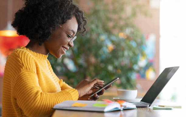 istock Happy afro girl freelancer using mobile phone 1205235813