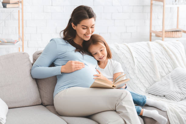 istock Happy family spending time together at home, reading book 1205236431