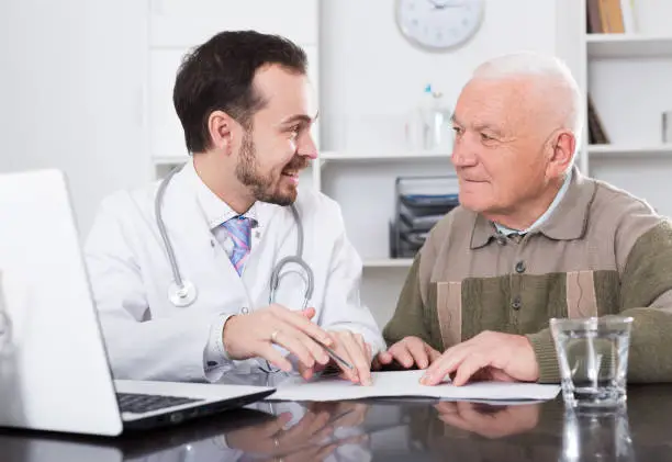 Elderly man comes to doctor in clinic for advice on health