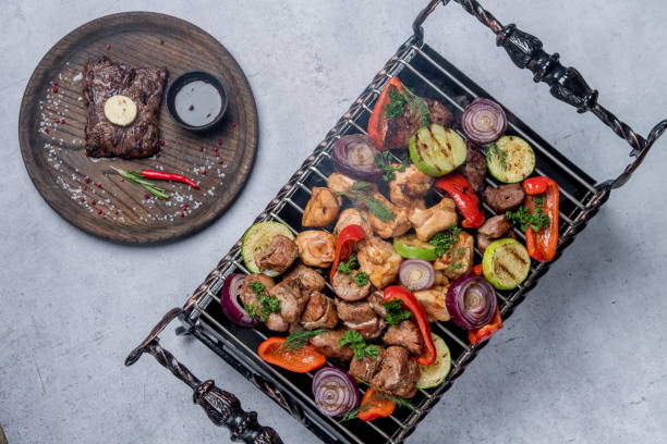 istock Assorted delicious grilled meat with vegetables next to a steak on a plate 1205238219