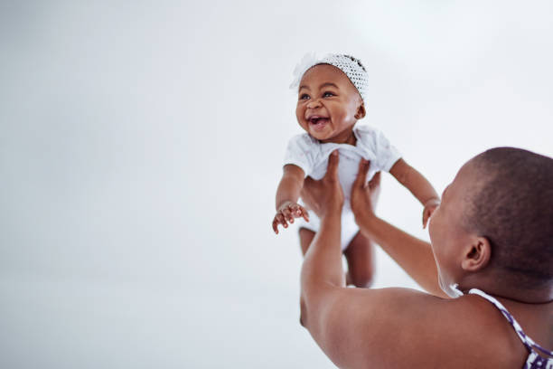 To hear her giggle is simply the cutest Shot of an adorable baby girl bonding with her mother at home mother and newborn stock pictures, royalty-free photos & images