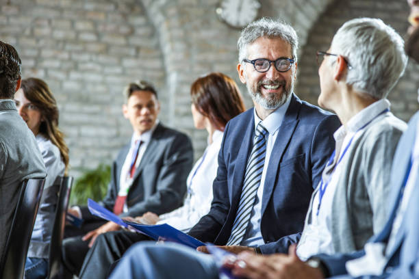 istock Happy business people talking while having a seminar in board room. 1205239974