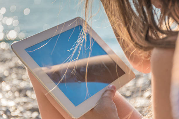 istock Content Girl on Summer Holiday Relaxing Using Digital Tablet on the Beach 1205240969