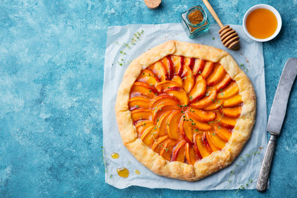 galette de melocotón, pastel, pastel con crema sobre fondo azul. vista superior. copiar espacio. - galette fotografías e imágenes de stock