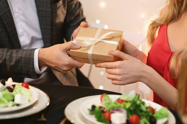 istock Man giving gift box to girlfriend on romantic dinner in restaurant 1205241622