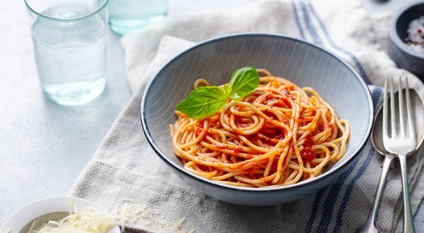 istock Pasta, spaghetti with tomato sauce and fresh basil in a bowl. Grey background. Copy space. 1205242703