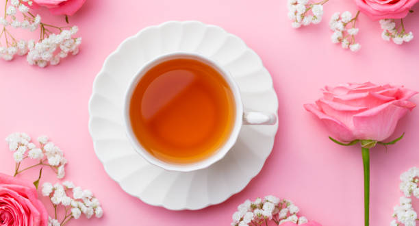 istock Cup of tea with fresh flowers on pink background. Copy space. Top view. 1205242939