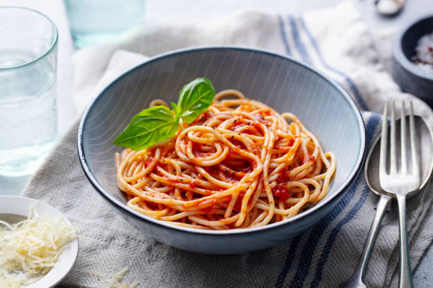 istock Pasta, spaghetti with tomato sauce and fresh basil in a bowl. Grey background. Close up. 1205243071