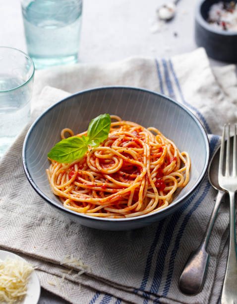 istock Pasta, spaghetti with tomato sauce and fresh basil in a bowl. Grey background. 1205243308
