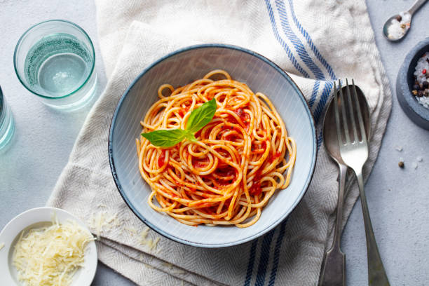 istock Pasta, spaghetti with tomato sauce and fresh basil in a bowl. Grey background. Top view. 1205243354