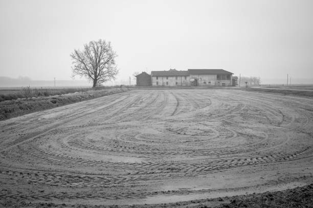 Old farm in the countryside region of Lomellina (between Lombardy and Piedmont, Northern Italy), famous for its rice cultivations, with its raw field before new season, wintertime.