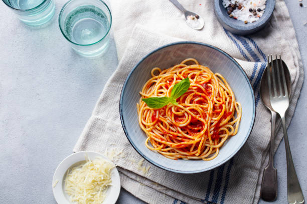 istock Pasta, spaghetti with tomato sauce and fresh basil in a bowl. Grey background. Top view. Copy space. 1205244629