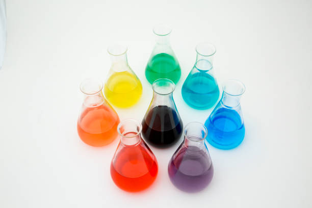 istock Scientific laboratory glass erlenmeyer flask filled with colorful liquid forming rainbow on white background. 1205245138