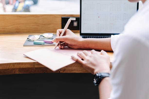 istock Close up of woman's hand writing in notebook 1205245203