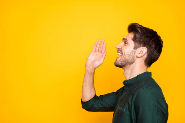 istock Profile side photo of cheerful positive handsome man shouting needed information into empty space nearby isolated white vivid yellow color background 1205245643