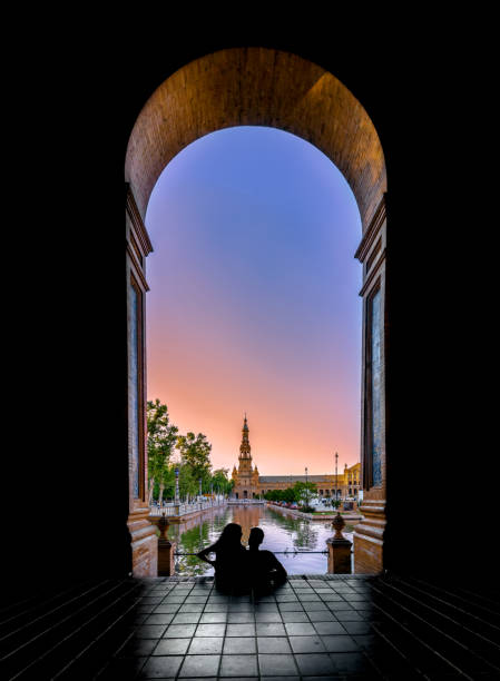 siluetas de pareja joven disfrutando de la puesta de sol en la famosa plaza de españa ( plaza de españa). sevilla, españa. - seville sevilla bridge arch fotografías e imágenes de stock