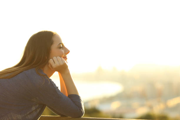 istock Woman with eyes closed relaxing at sunset 1205251385