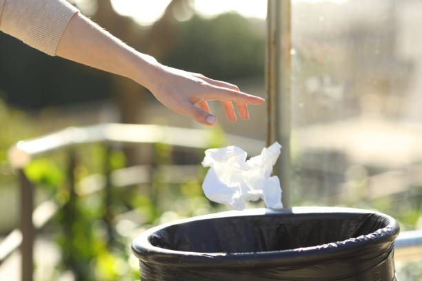 istock Hand throwing litter into bin in a park 1205251980