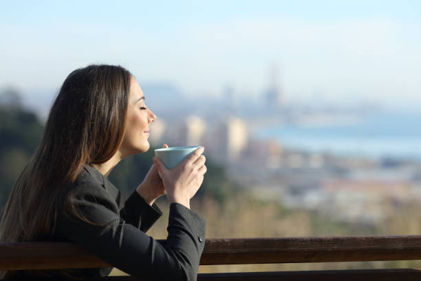 istock Relaxed businesswoman drinking coffee on a bench 1205252077