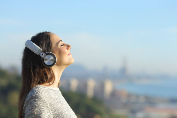 frau hört musik atmen im freien - city life audio stock-fotos und bilder