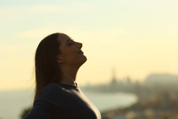 istock Woman silhouette breathing deeply fresh air at sunset 1205252224