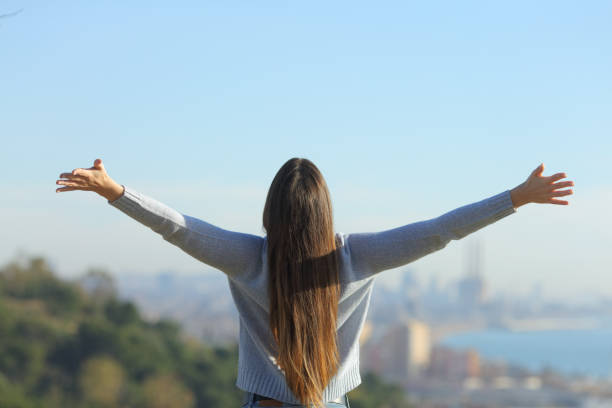 istock Woman stretching arms looking at city background 1205252312