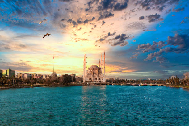 moschea centrale sabanci, vecchia torre dell'orologio e ponte di pietra ad adana, città della turchia. adana city con minareti della moschea di fronte al fiume seyhan. - surrounding wall sky river dome foto e immagini stock