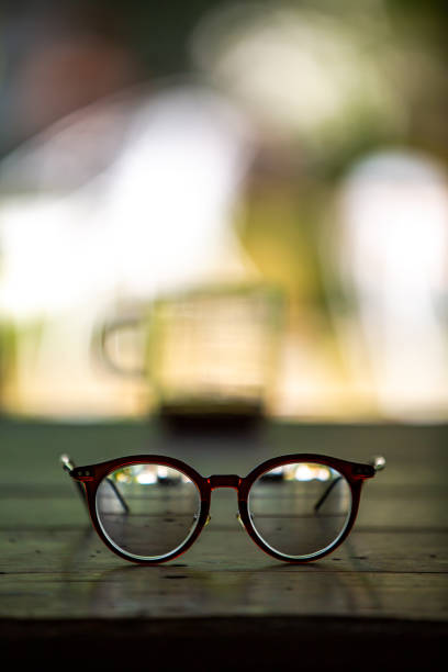 istock Eyeglasses, Coffee glasses cup with coffee stains stuck on them, then after drinking it on wooden table in bokeh blurred green garden background, Close up shot, Selective focus 1205254382