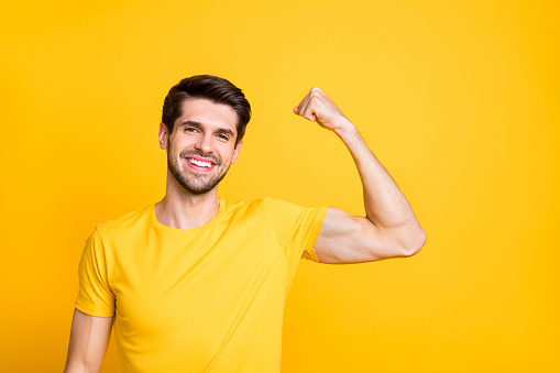 Close-up portrait of his he nice attractive content sportive cheerful cheery, guy demonstrating muscles motivation isolated over bright vivid shine vibrant yellow color background