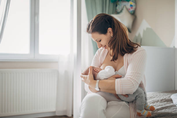 mother breastfeeding her baby boy at home - simplicity purity new life innocence imagens e fotografias de stock