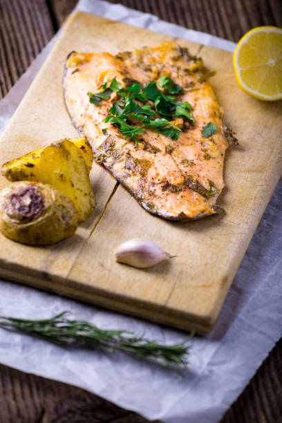 istock Trout with potateos on wooden board. 1205257733