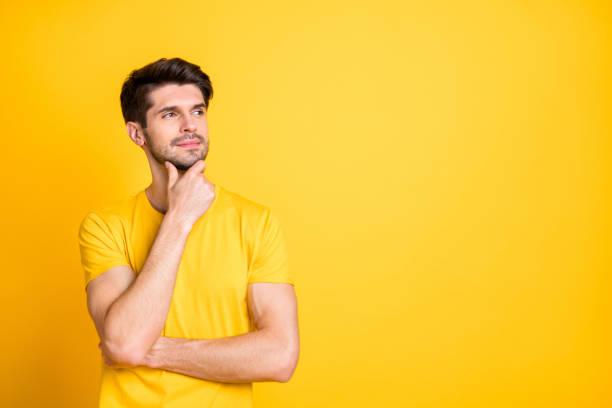istock Portrait of his he nice attractive minded pensive creative brown-haired guy wearing tshirt thinking touching chin copy space isolated over bright vivid shine vibrant yellow color background 1205258078