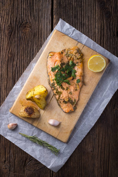 Trout with potateos on wooden board. stock photo