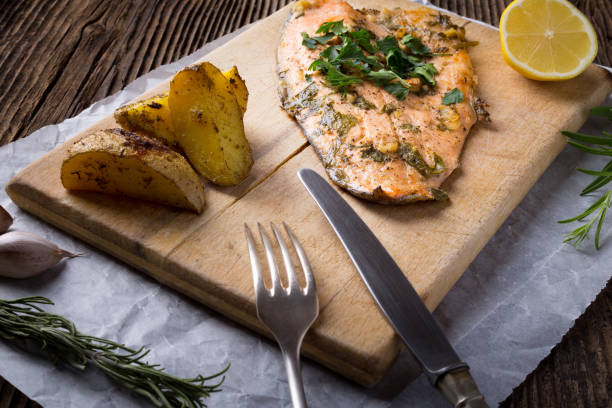 istock Trout with potateos on wooden board. 1205258208
