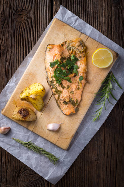Trout with potateos on wooden board. stock photo