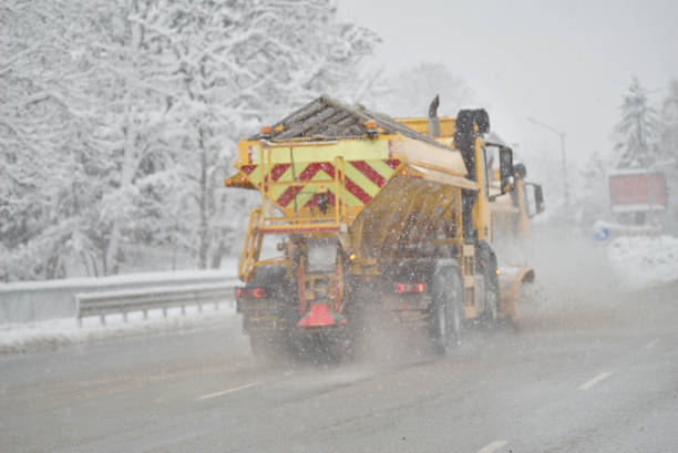 A snowplow and salting truck cleaning a highway.