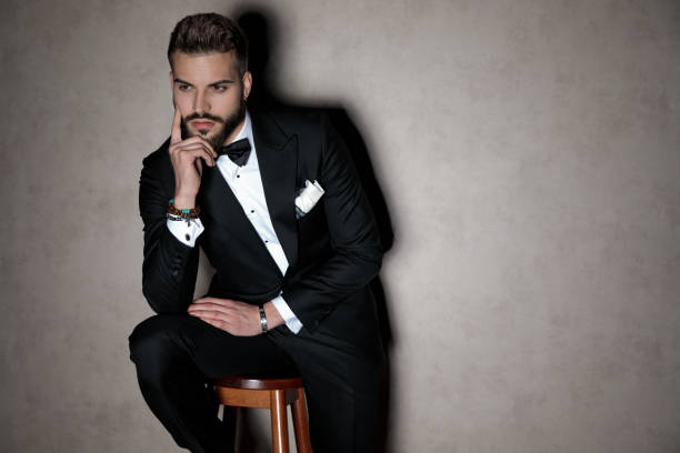 Handsome groom holding his hand on his chin
