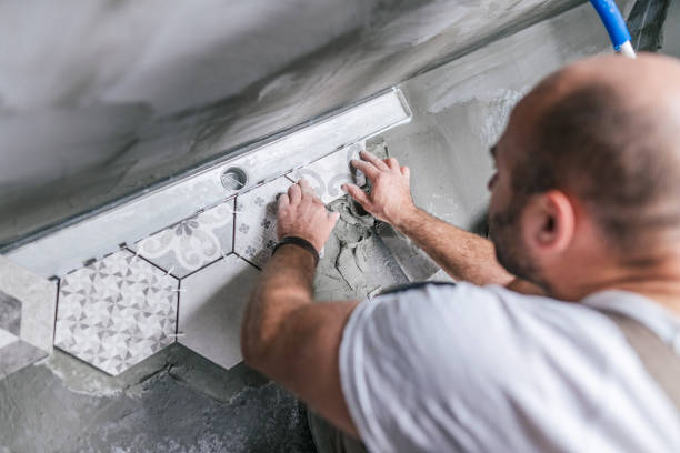 istock Male tiler installing tiles on the bathroom floor 1205260126