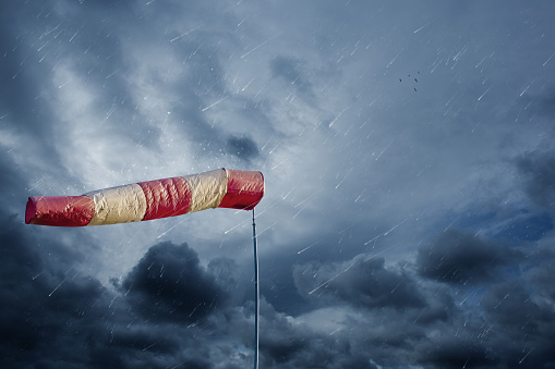Calcetín de aire que mide la velocidad del viento en tiempo tormentoso. Concepto de huracán, tornado y tormenta. photo