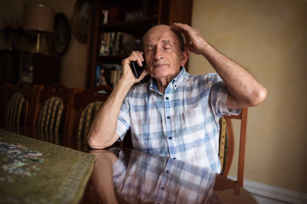 istock Depressed senior man talking on phone 1205261357
