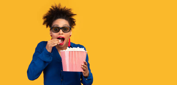 istock Millennial afro woman with popcorn looking at camera 1205261747