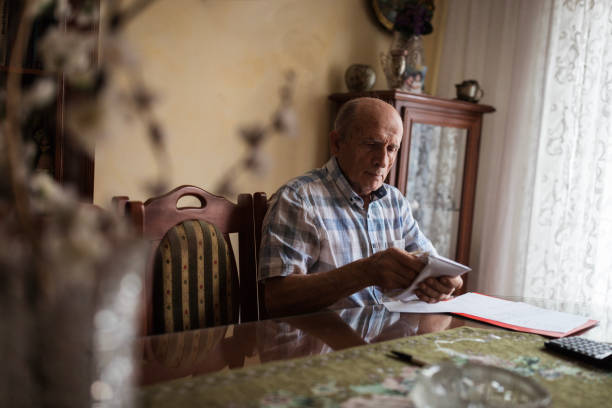 istock Elderly man packing his pension money into an envelope 1205263682