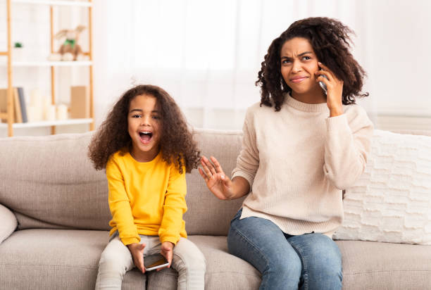 istock Little Daughter Shouting While Mother Talking On Phone At Home 1205264637