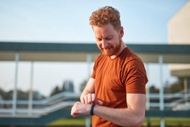 istock Young man using hand watch during exercising / stretching in urban park. 1205267331