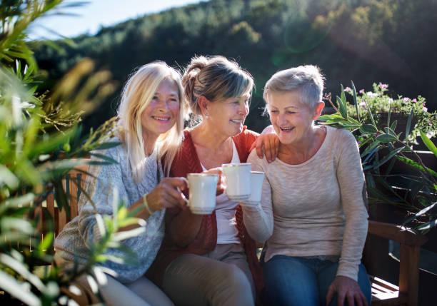 istock Senior women friends sitting outdoors on terrace, resting. 1205269713