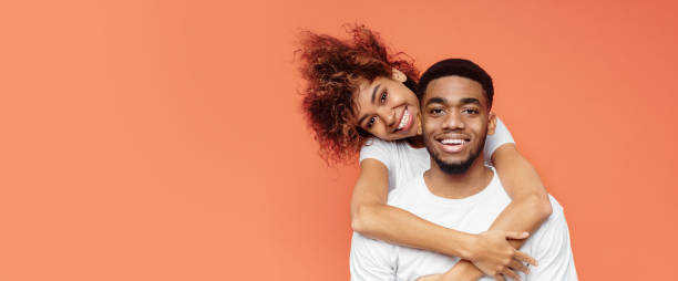 istock Loving African American Couple Hugging Posing Over Orange Background, Panorama 1205270032