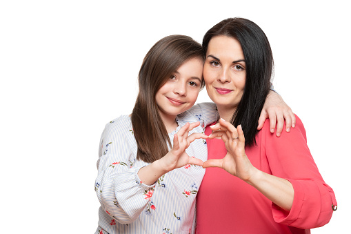 Cute girl and her mother making together heart shape hand gesture. Family love, care and support. Mom and daughter love connection concept.