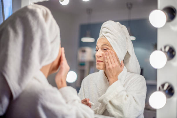 istock Mature woman applying face cream. 1205272070